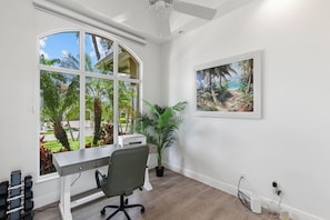 A modern office space with a desk, chair, and large windows overlooking a garden. - Waterfront Marco Island Home w/ Pool, Spa & Kayaks (Marco Island)