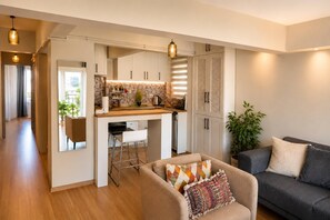 A modern kitchen with white cabinets, a wooden countertop, and pendant lighting. - Cozy Bright 1Bd Near Bosphorus (Istanbul)
