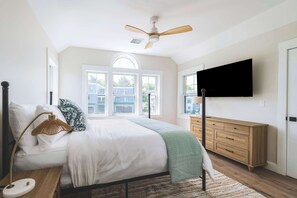 A bedroom with a bed, bedside table, lamp, dresser, and a ceiling fan. - Stay at Good Harbor Beach (Gloucester)