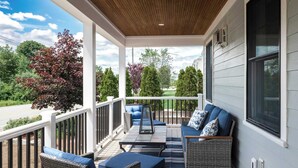 A covered porch with outdoor furniture, a view of the neighborhood, and a wooden ceiling. - Stay at Good Harbor Beach (Gloucester)