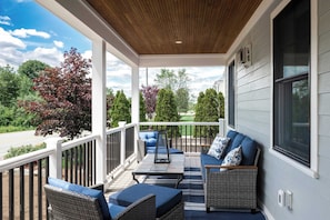 A covered porch with outdoor furniture, a view of the neighborhood, and a wooden ceiling. - Stay at Good Harbor Beach (Gloucester)
