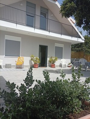 A two-story building with a balcony, potted plants, and outdoor furniture. - Don Turi Etna (Zafferana Etnea)