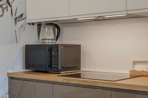 Eine Küche mit Mikrowelle, Kaffeemaschine und einer Packung Nespresso-Kapseln.