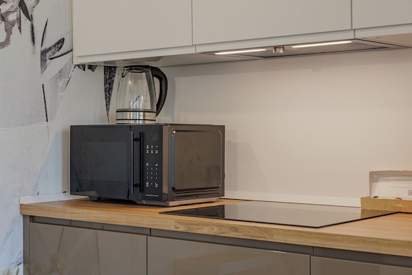 Eine Küche mit Mikrowelle, Kaffeemaschine und einer Packung Nespresso-Kapseln.