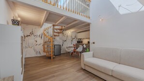 Un interior moderno con una escalera de madera, un comedor y un sofá.