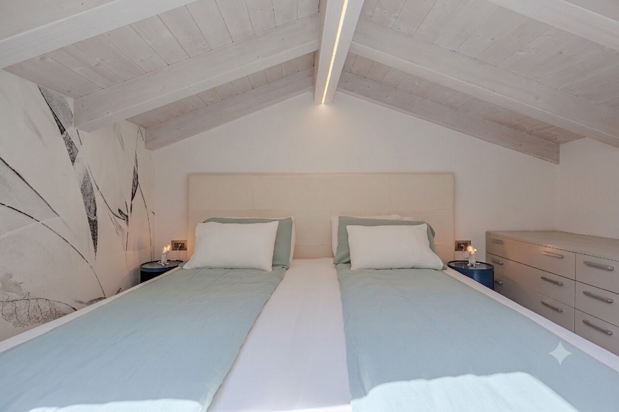 Une chambre avec deux lits, une table de chevet avec une lampe et une commode.