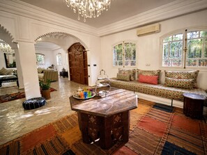 Ein traditionelles Interieur mit einer Sitzecke, einem Ziertisch und einer großen Holztür.