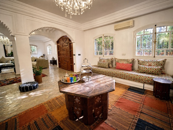 A traditional interior with a seating area, a decorative table, and a large wooden door.