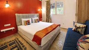 A bedroom with a bed, a sofa, a window, and a red wall. - Beautiful, quiet house in Marrakech, 7 bedrooms, pool, and live-in cook (Marrakech)