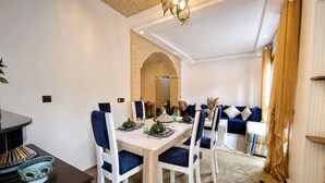 A dining area with a stone wall, a wooden ceiling, and a blue upholstered sofa. - Beautiful, quiet house in Marrakech, 7 bedrooms, pool, and live-in cook (Marrakech)