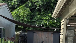 Ein Patio mit Stuhl, Tisch und Holzlattenzaun.