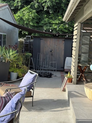 Ein Patio mit Stuhl, Tisch und Holzlattenzaun.