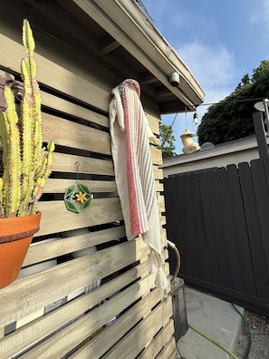 A wooden slatted wall with a potted cactus, a hanging towel, and a small decorative item. - Beautiful 2 Unit Retreat locally situated in Noho West (Los Angeles)