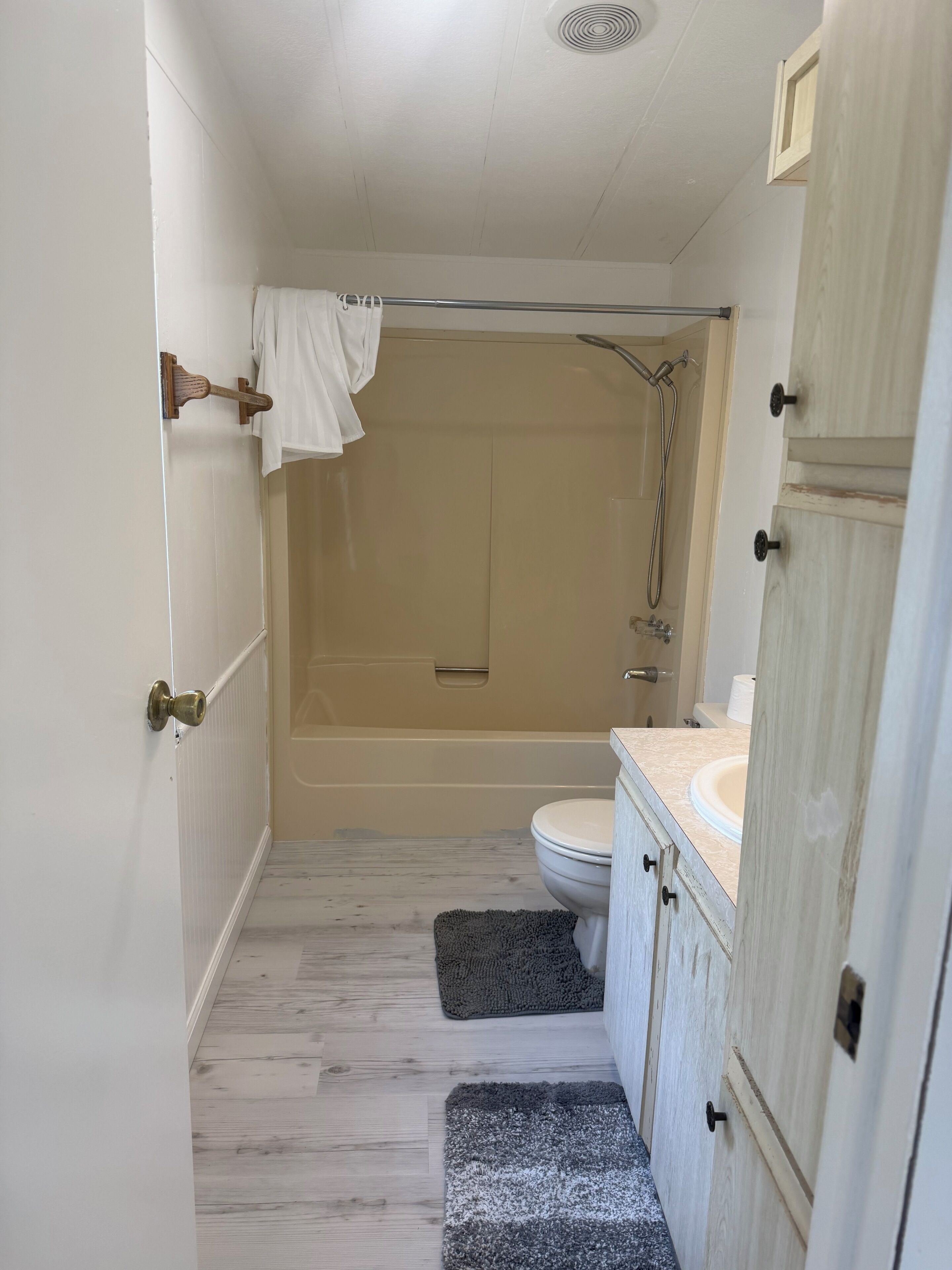 A bathroom with a shower, toilet, and vanity.