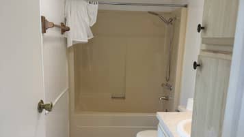 A bathroom with a shower, toilet, and vanity.