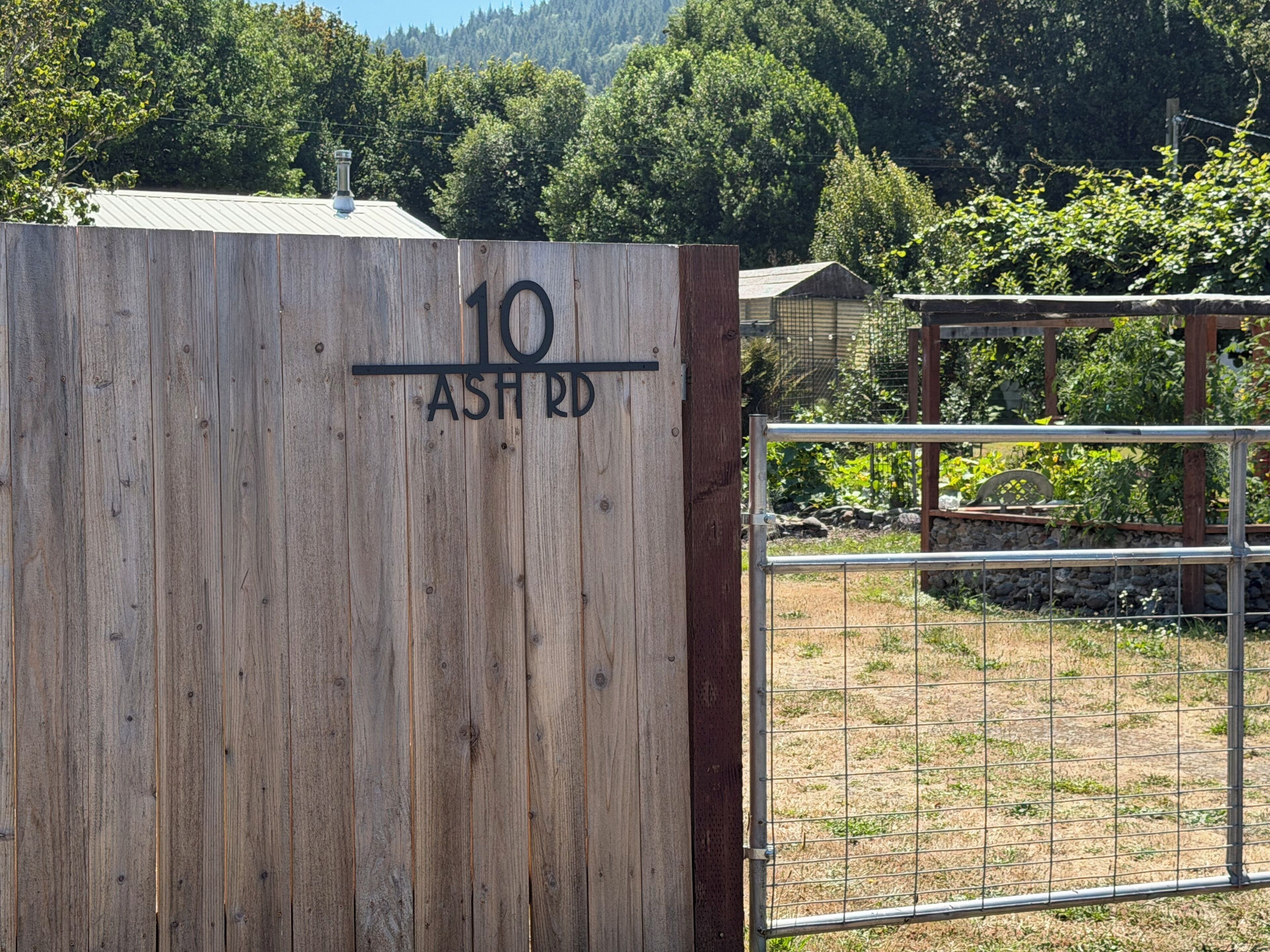 Une porte en bois avec une clôture en métal, un poteau en bois et un portail en métal.