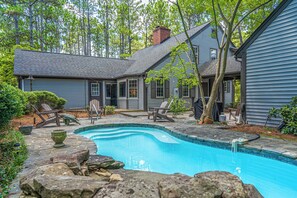 A residential property with a swimming pool, outdoor seating, and a covered patio area. - The Midland Clubhouse - Pool and Golf Simulator! (Pinehurst)