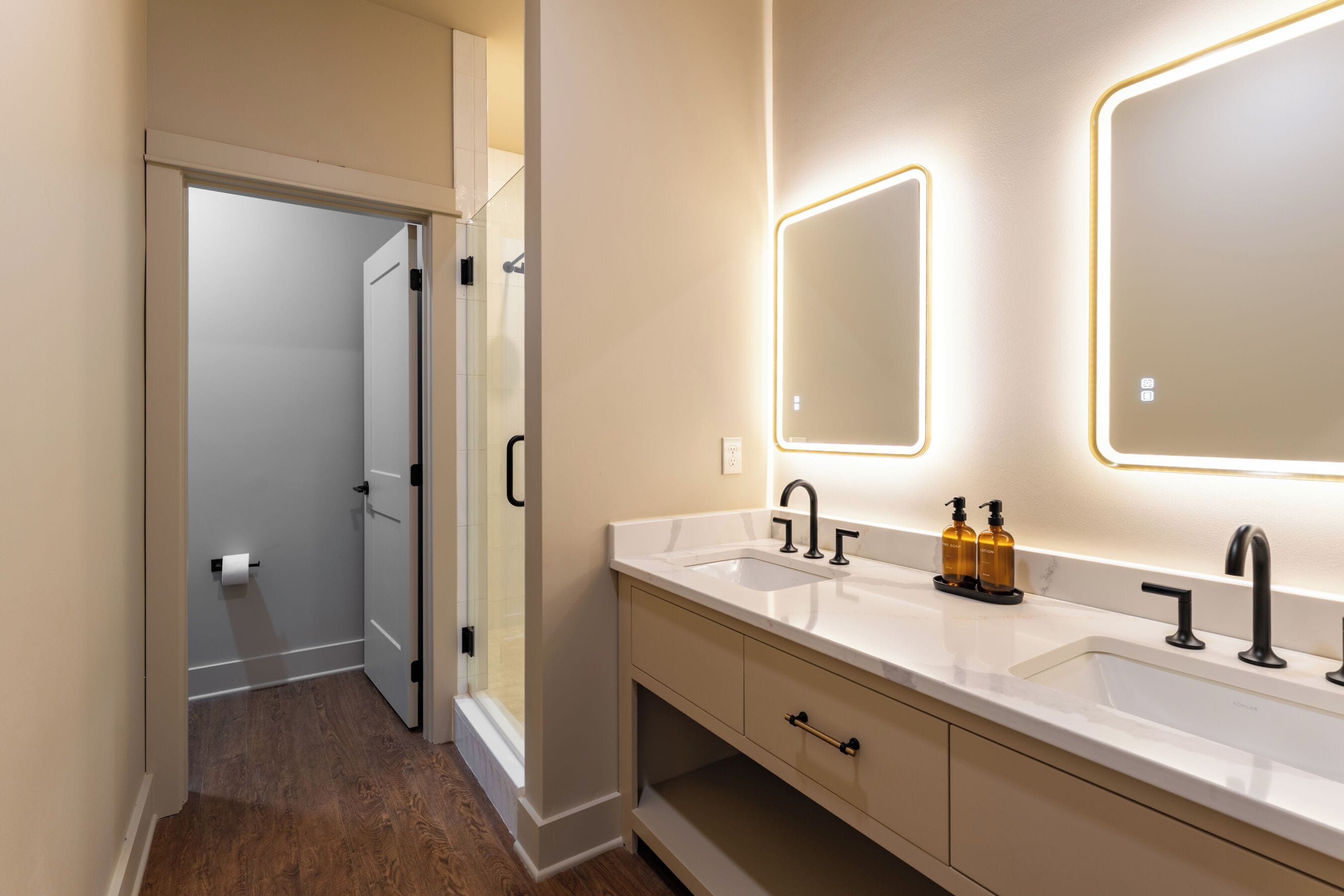 A modern bathroom with a double sink, a mirror, and a shower.