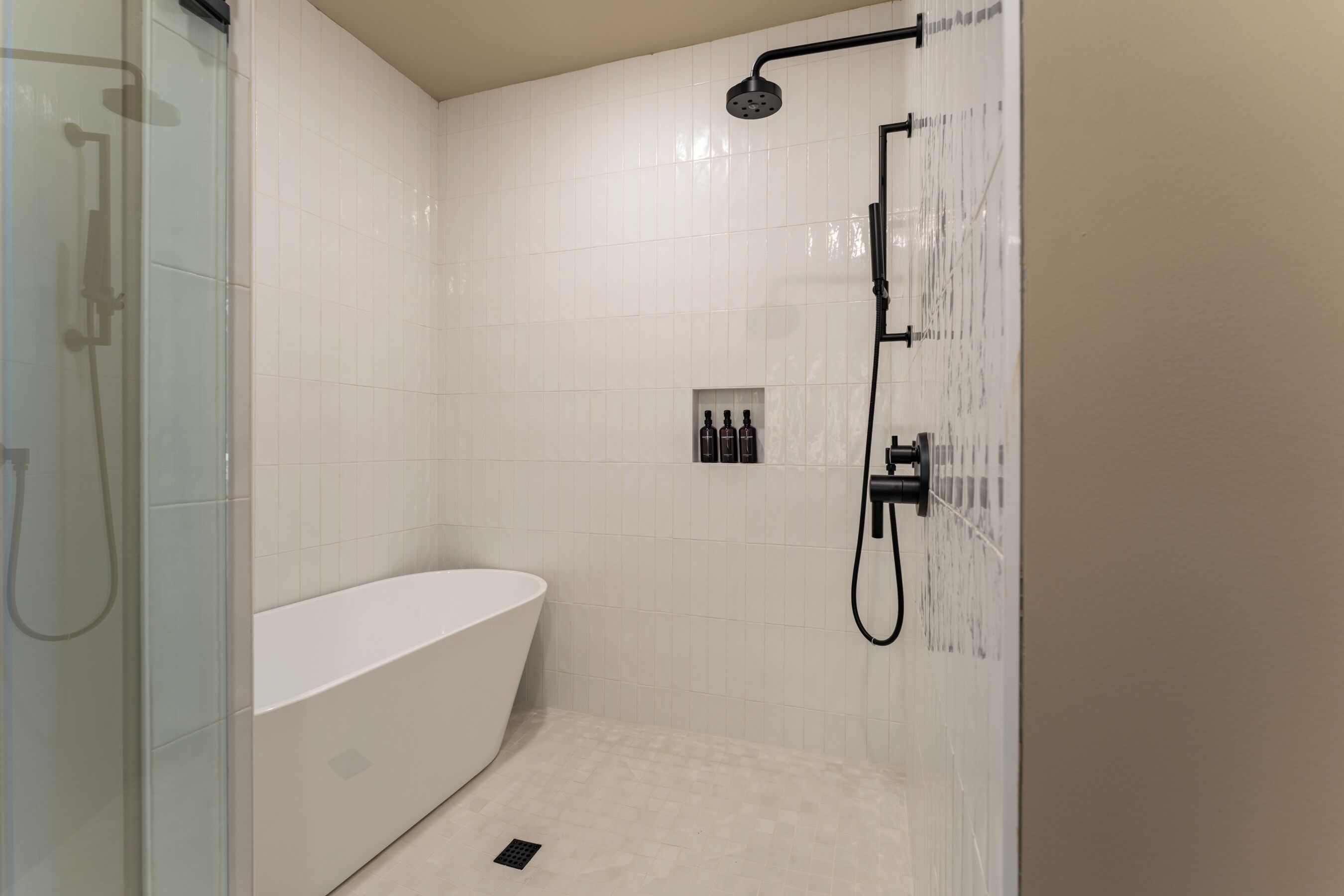 A modern bathroom with a freestanding bathtub, a glass shower enclosure, and a wall-mounted showerhead.