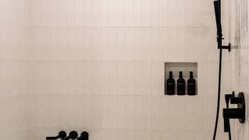 A bathroom with a freestanding bathtub, a handheld showerhead, and a wall-mounted faucet.