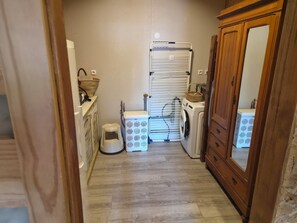 A laundry room with a washing machine, dryer, and drying rack. - Gîte Le Rucan Atypical house in the Pyrenees Commingeoises (Montastruc-de-Salies)