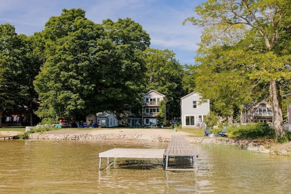 A lakeside property with a dock and a house with a balcony.