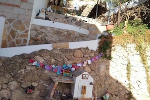 A stone staircase leading to a white building with a small shrine at the bottom. - The Little House of the Tooth Fairy (Navarrés)