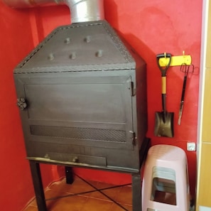 A wood-burning stove with a chimney, a shovel, and a water dispenser. - The Little House of the Tooth Fairy (Navarrés)