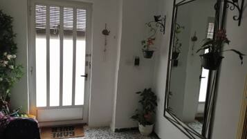 A room with a door, a large mirror, and potted plants.
