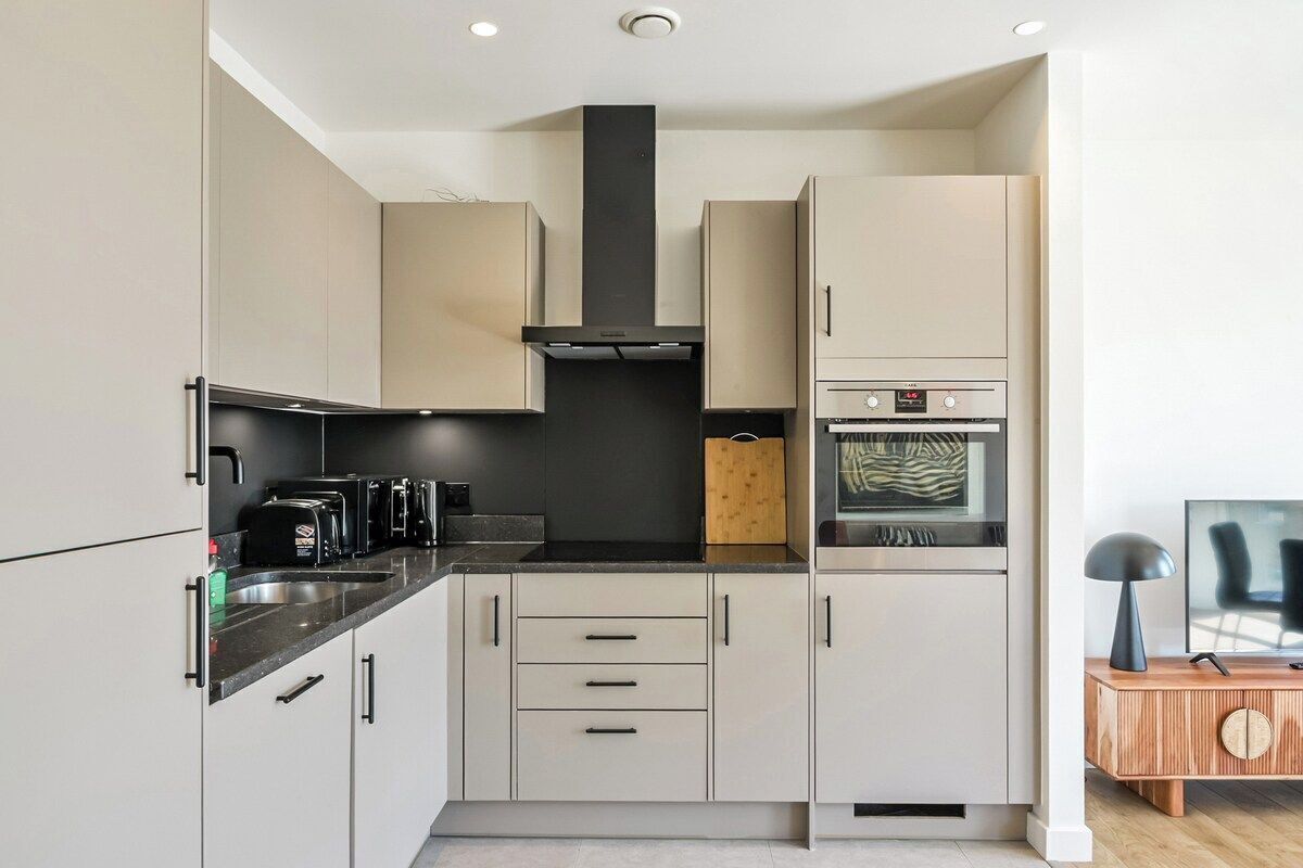 A compact kitchen with a built-in oven, a coffee maker, and a microwave.