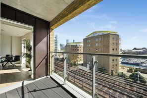 A balcony with a view of a cityscape, including buildings and a canal. - Canary Boutique – Modern 2 Bed Apartment (Greater London)