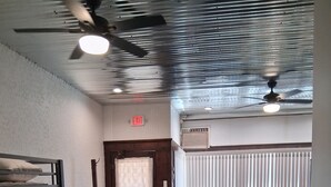 A hotel room with a bunk bed, a desk, a chair, a dining table with chairs, and a ceiling fan. - Historical Main Street Studio in Charming La Crosse (La Crosse)