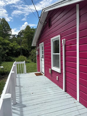 A house with a red exterior, a white porch, and a door with a window. - Peaceful Vintage Charm in North Asheville (Asheville)