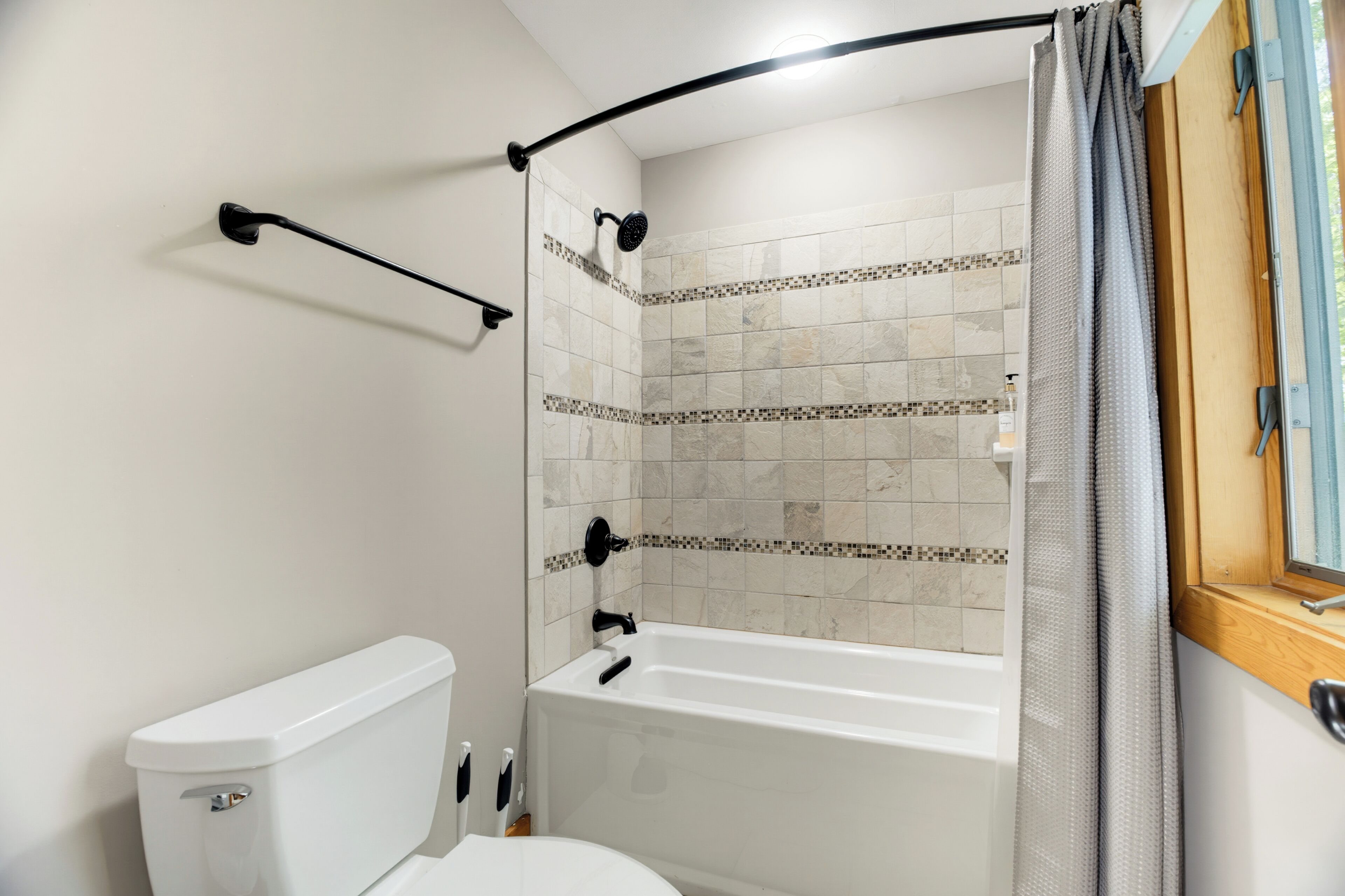 Un bagno con il water, una vasca e uno spazio doccia.