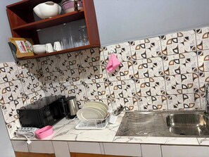 Una cocina con salpicadero estampado, un fregadero y diversos utensilios.