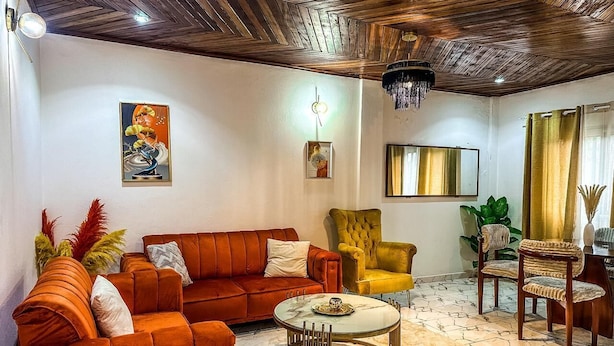 Una sala de estar con sofá, sillón y una mesa redonda de centro.