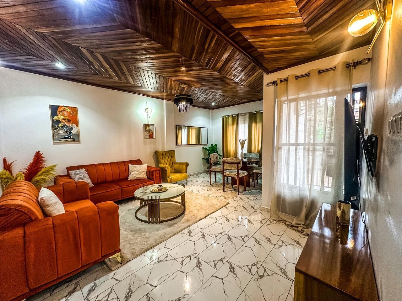 A living room with a sofa, a coffee table, and a dining area with chairs.