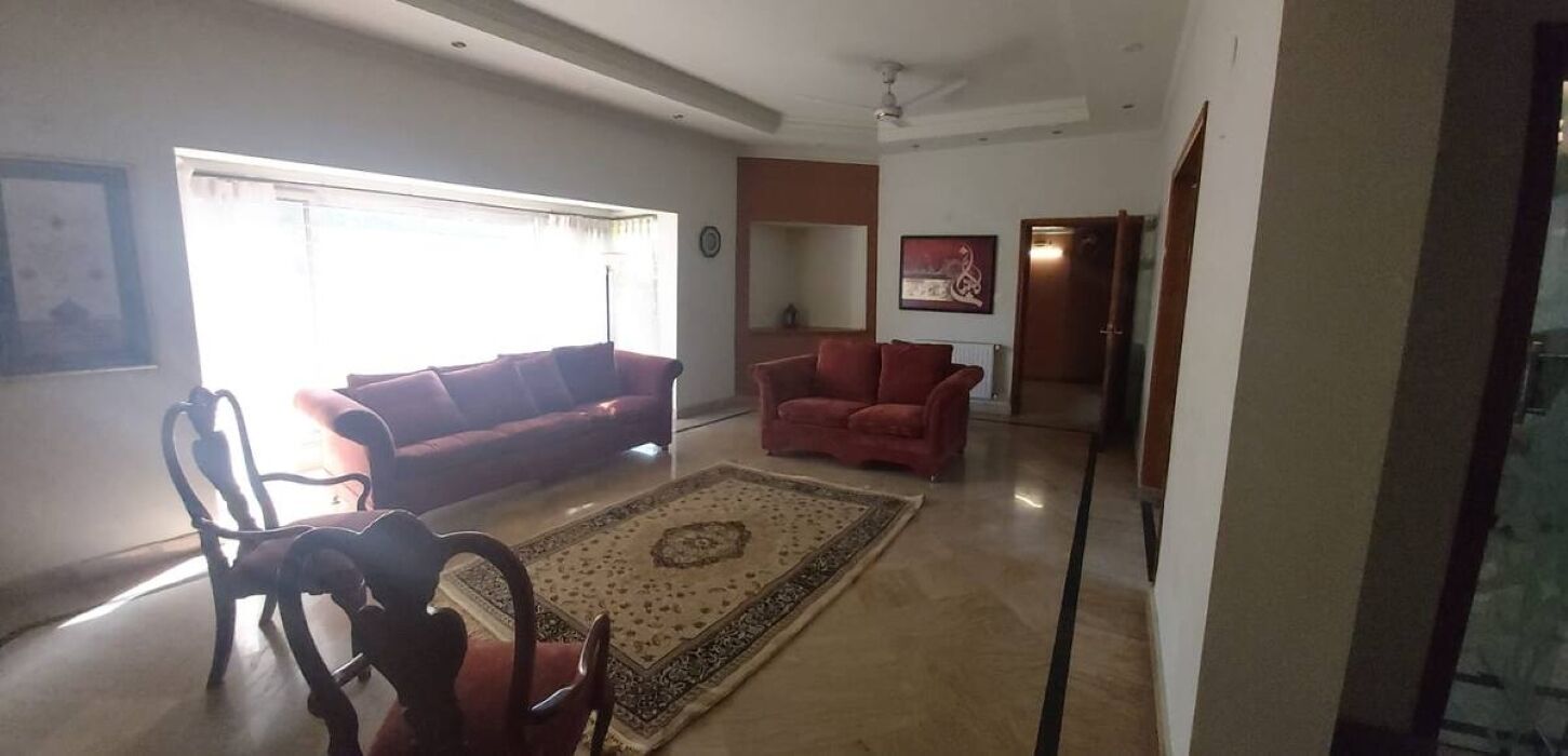 A living room with a sofa, armchairs, a coffee table, and a rug.