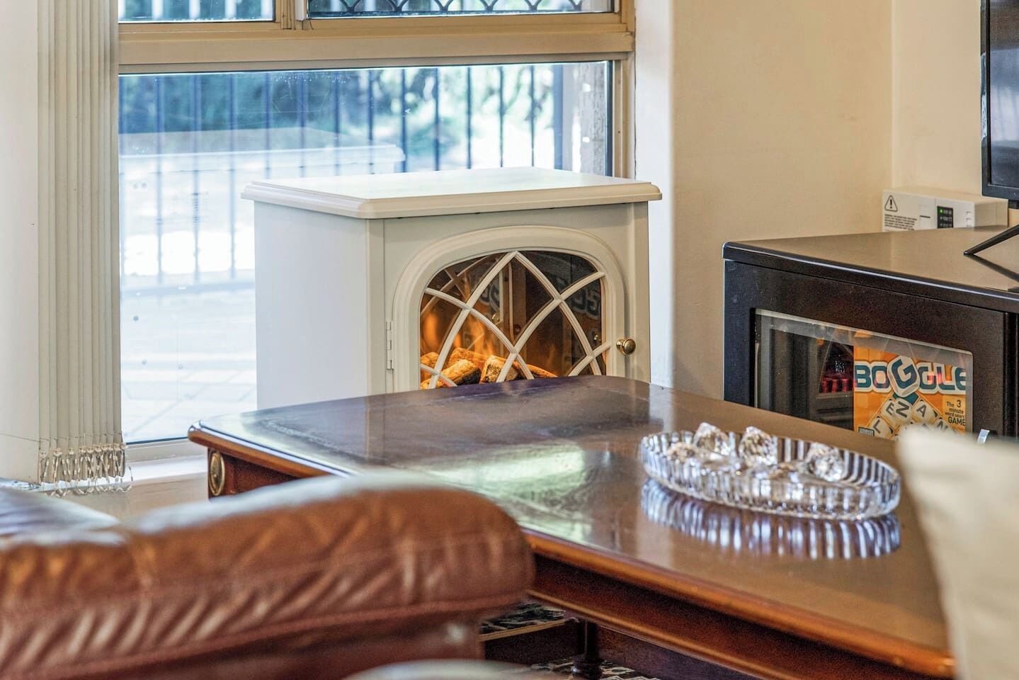 A cozy room with a fireplace, a table with a tray of snacks, and a television.