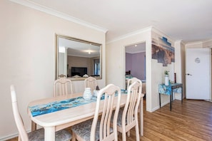 A dining area with a table, chairs, and a large mirror. - Mandurah Coastal Getaway|Dolphins|Beaches|Sleeps 6 (Mandurah)