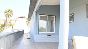 A balcony with a view of the street, a window, and a railing.