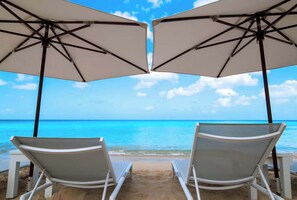 Two beach chairs under umbrellas facing a clear blue sea. - Porters Place 2 | Modern West Coast Villa Near Holetown (Holetown)