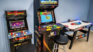 Two arcade machines, a table tennis table, and two stools in a room. - Large Vacation House w/ Game Room 10-min Down Town (Las Vegas)