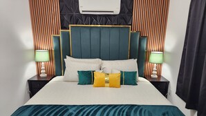 A bed with a headboard, pillows, and a blanket. There is a wall-mounted air conditioner above the bed. - Large Vacation House w/ Game Room 10-min Down Town (Las Vegas)