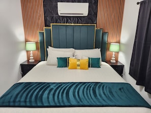 A bed with a headboard, pillows, and a blanket. There is a wall-mounted air conditioner above the bed. - Large Vacation House w/ Game Room 10-min Down Town (Las Vegas)