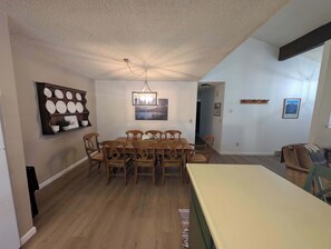 A dining area with a wooden table and chairs, a wall-mounted plate rack, and a ceiling fan. - Paw's For Awhile - 55 Ponderosa (Plumas Eureka)
