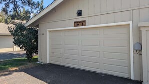 A garage door with a plaque, a mailbox, and a number '55' on the wall. - Paw's For Awhile - 55 Ponderosa (Plumas Eureka)