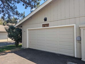 A garage door with a plaque, a mailbox, and a number '55' on the wall. - Paw's For Awhile - 55 Ponderosa (Plumas Eureka)