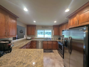 A modern kitchen with granite countertops, stainless steel appliances, and wooden cabinets. - Pondy - 101 Ponderosa (Plumas Eureka)