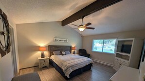 A bedroom with a bed, nightstands, a ceiling fan, a window, and a TV. - Pondy - 101 Ponderosa (Plumas Eureka)